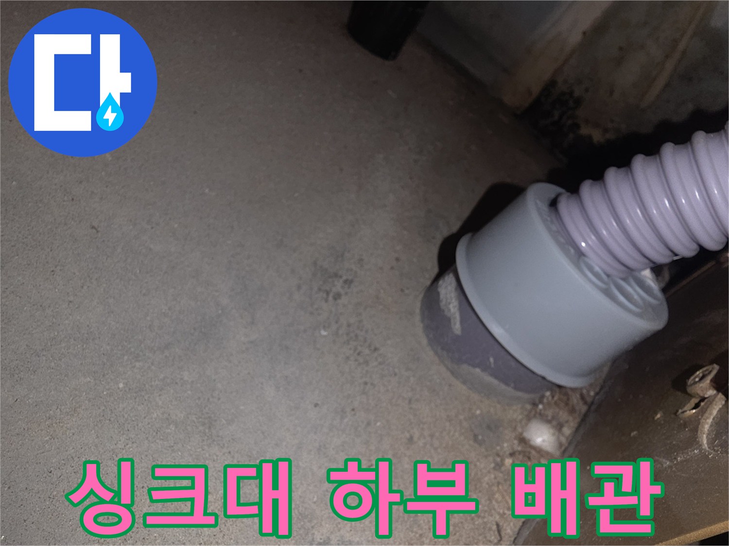 주방 싱크대 아래쪽의 회색 주름관과 연결 부위 모습