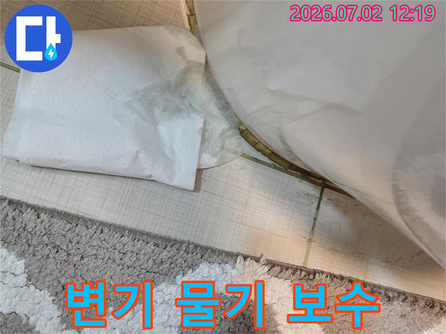 변기 하부에서-물이 새어-나와-바닥에-물기가-고여있는-누수-현장을-보여주는-사진입니다.