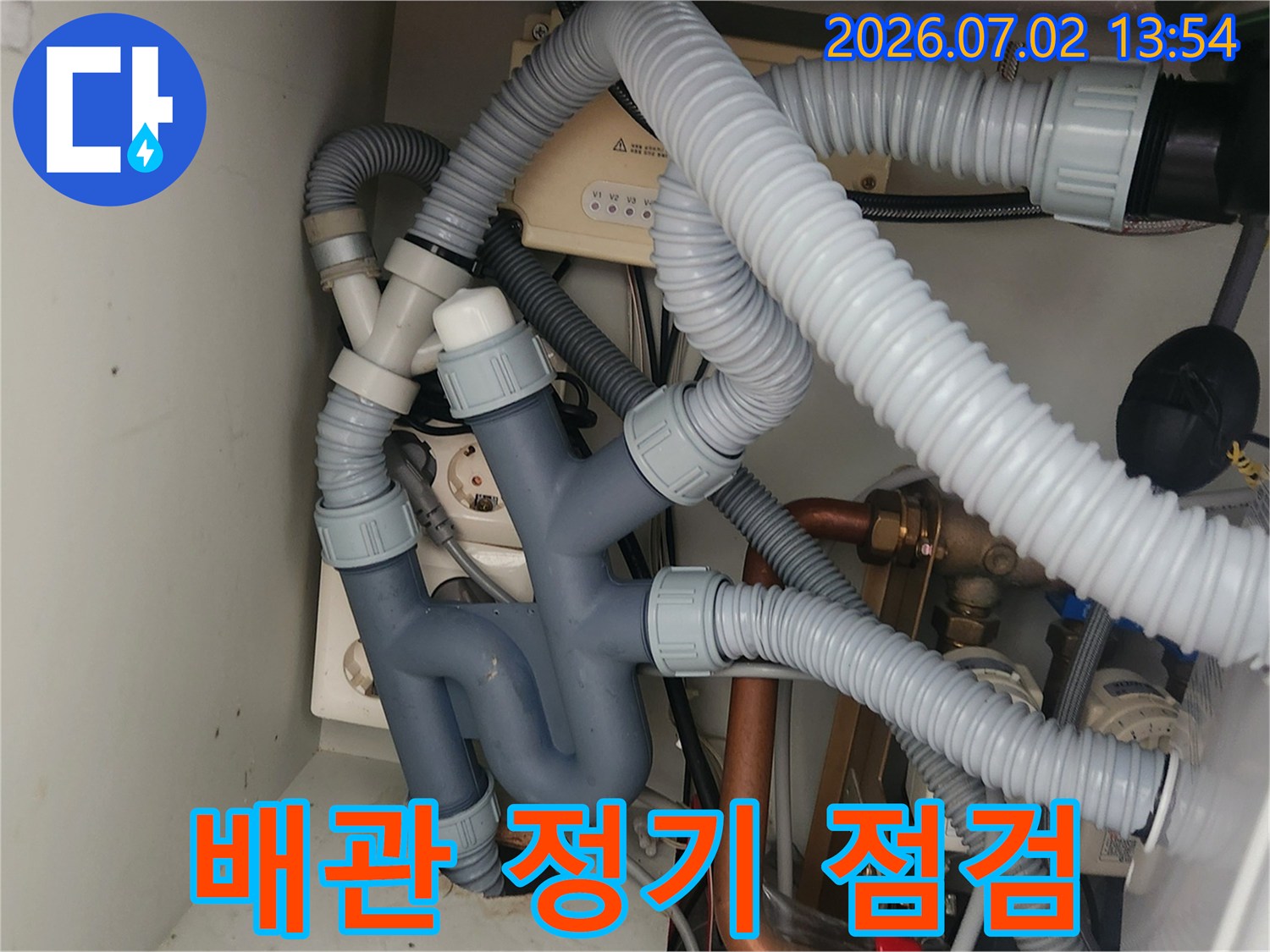 이 사진은-싱크대 하부의-다양한 배관들을-전문가가 꼼꼼하게-점검하는 모습을-보여주며-사전 예방의-중요성을 강조합니다.