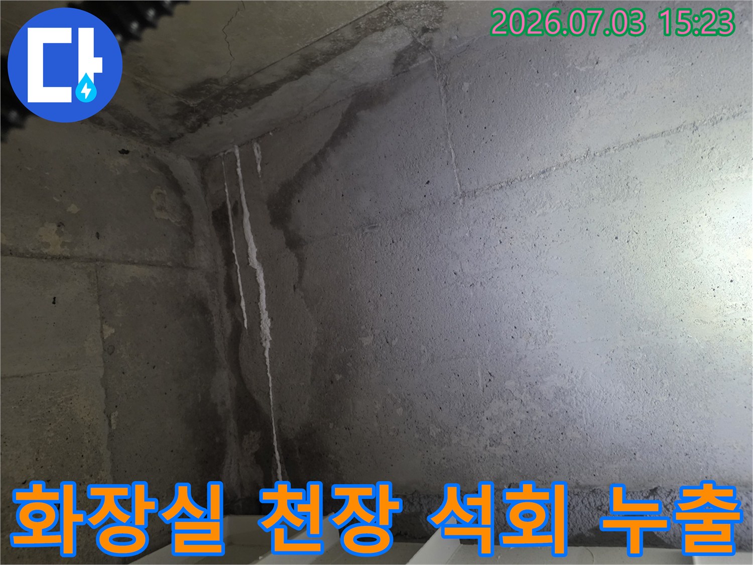 하얀색 석회 자국이 선명하게 남은 화장실 천장의 콘크리트 벽면 모습