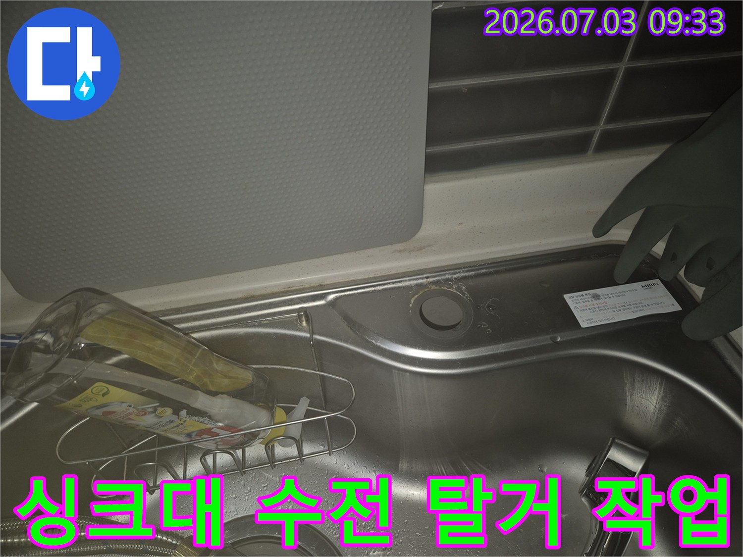 싱크대 배수구 근처에 위치한 노후된 수전을 제거하는 과정의 모습