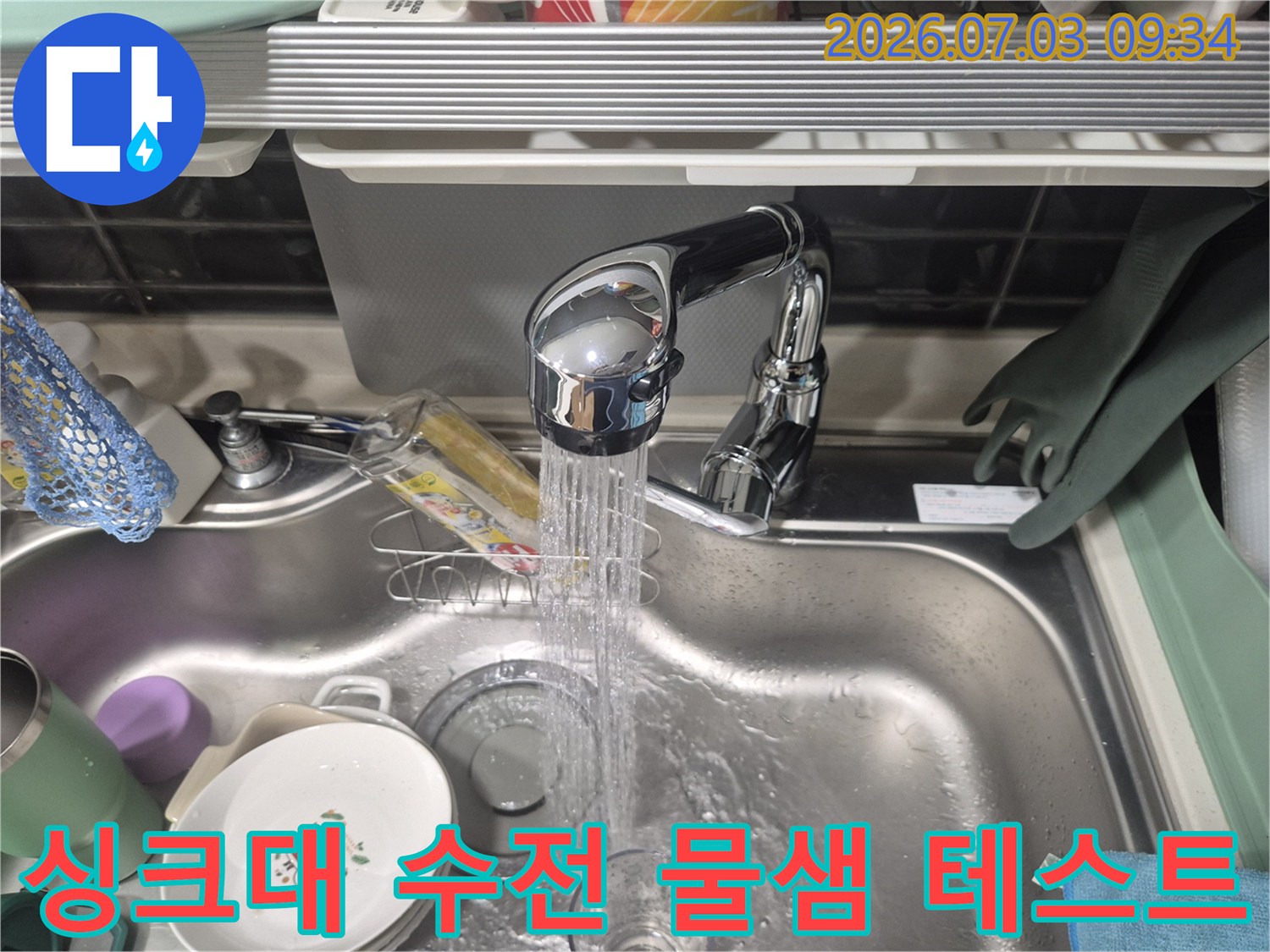 싱크대 수전에서 쏟아지는 물과 세척용품이 놓인 개수대 모습