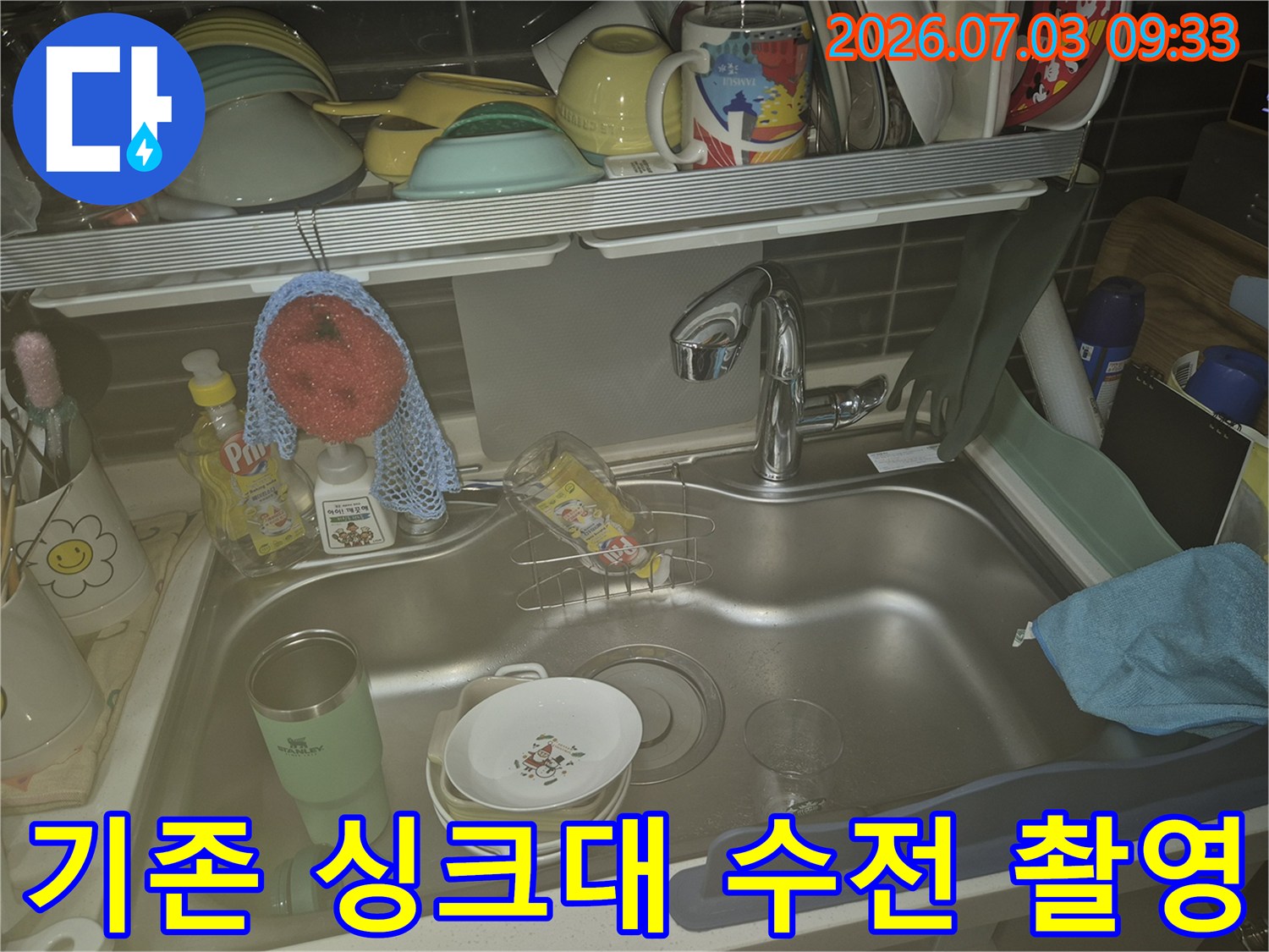 주방 세제와 수세미가 놓인 싱크대 공간에 설치된 기존 수전