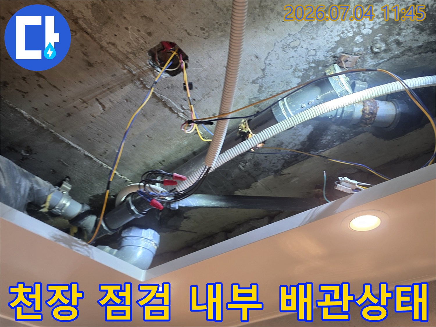 화장실 천장 안쪽의 여러 가지 배관과 연결 부위가 얽혀있는 모습