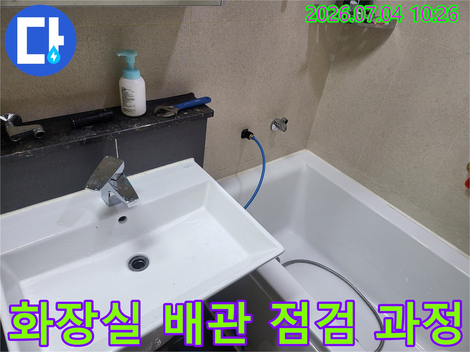 세면대 옆 공간에 위치한 노출 배관 및 호스 연결 부위 정밀 확인