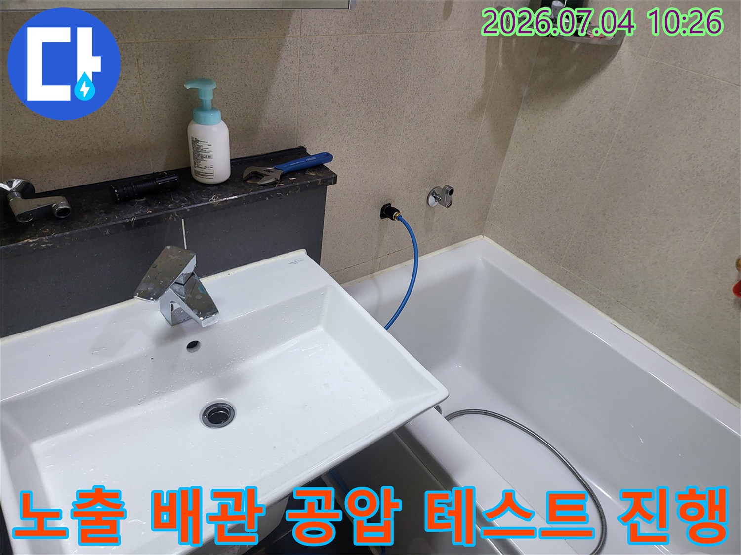 세면대 옆 수도 라인에 연결된 장비를 통해 실시간으로 압력을 체크하는 누수 점검 과정