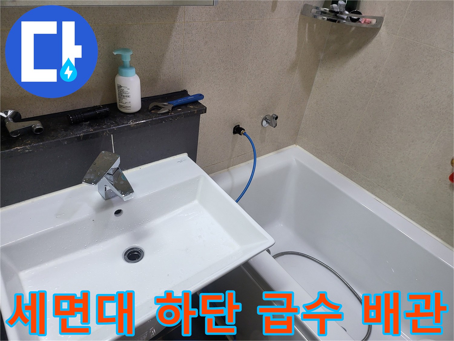 화장실 세면대 아래 벽면에 설치된 수도 밸브와 배관 연결 상태