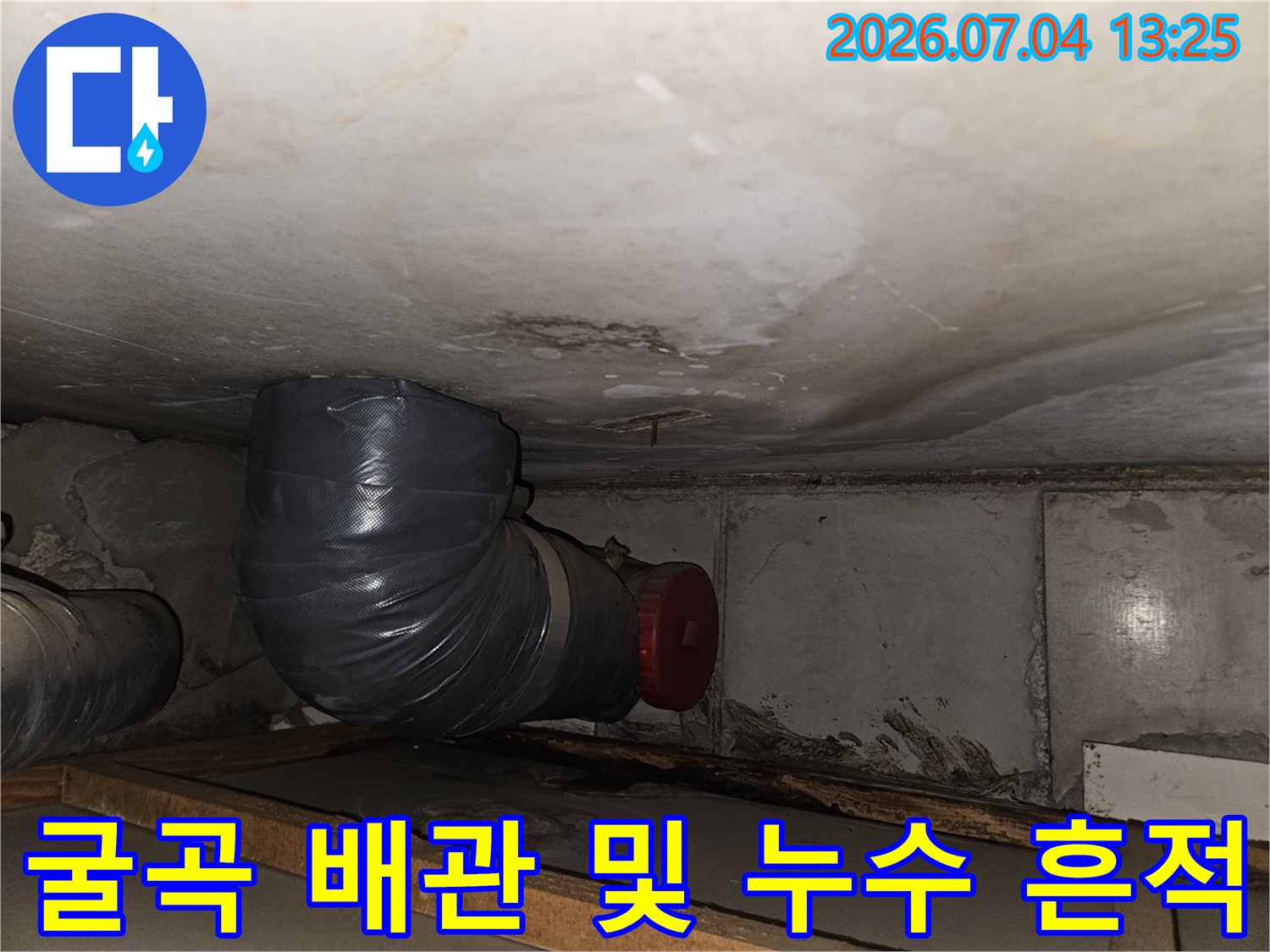 화장실 천장 안쪽의 굴곡진 배관과 빨간색 마감재 부분