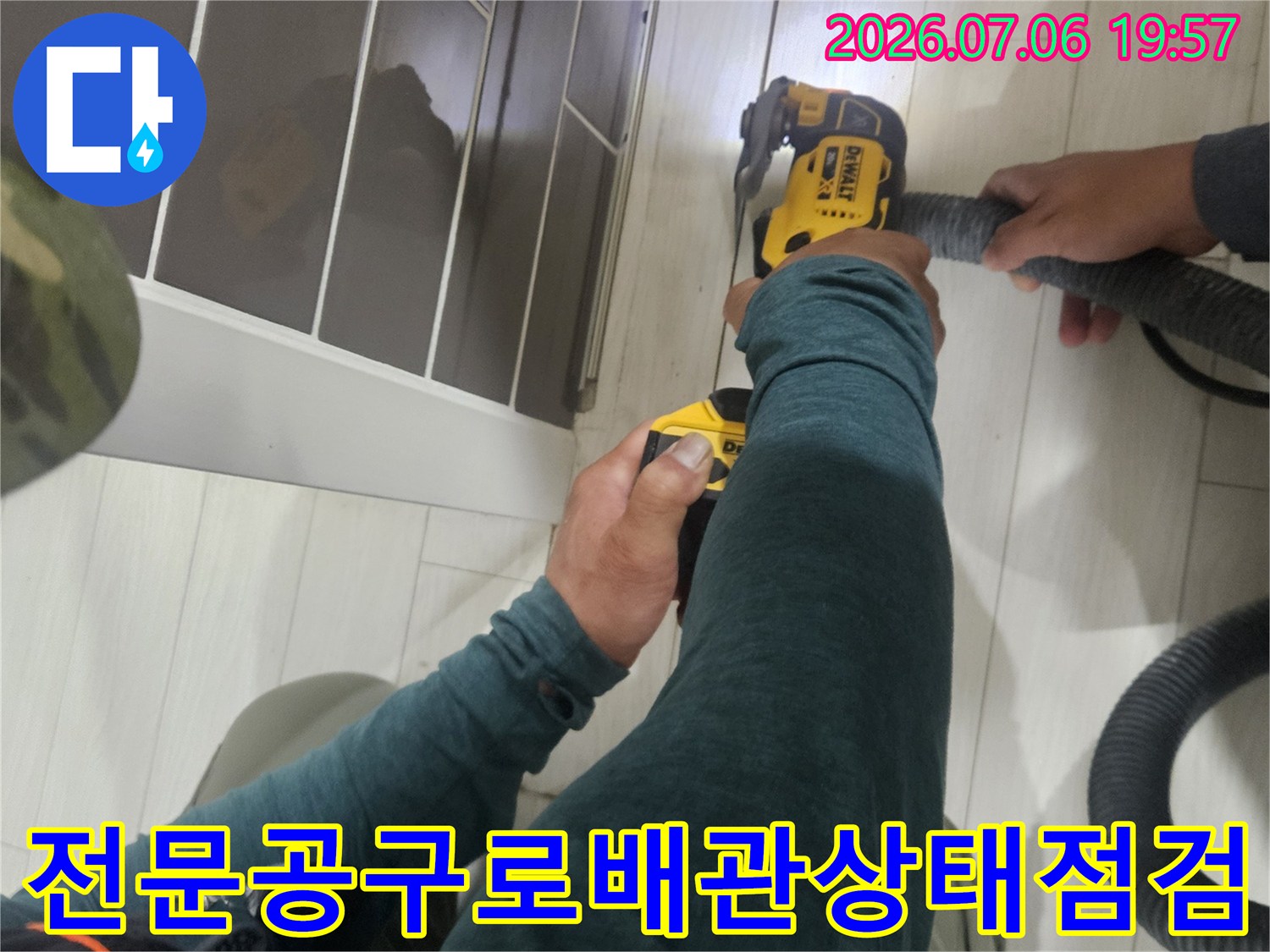 노란색 소형 장비를 사용하여 노출된 배관의 이상 유무를 상세하게 점검함