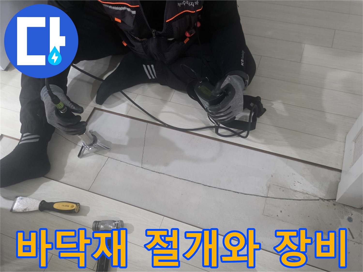 누수 지점 확인을 위해 강마루를 절개하고 전동 공구를 준비한 모습입니다.