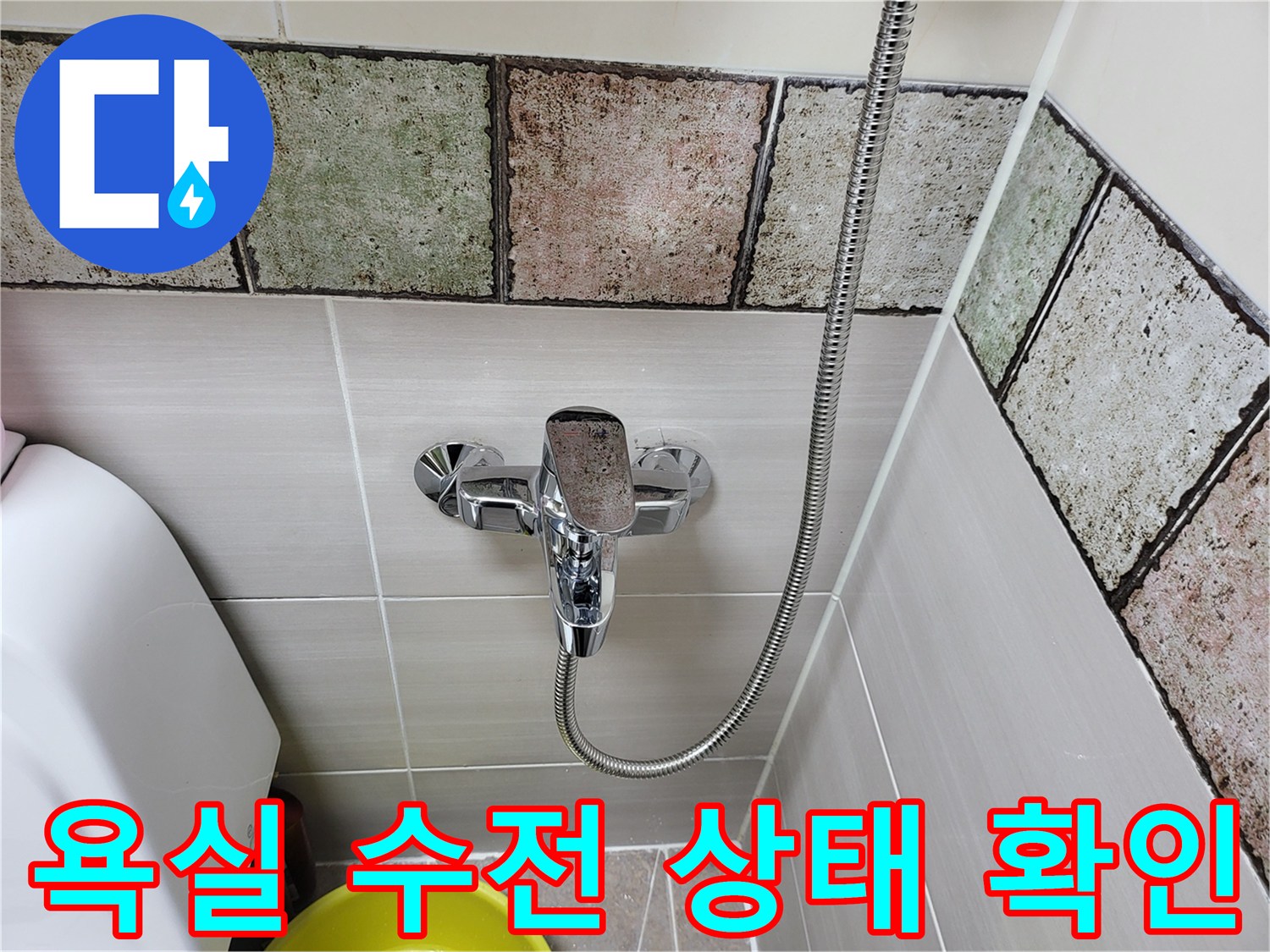 욕실 벽면에 설치된 샤워 수전과 타일 모습입니다.