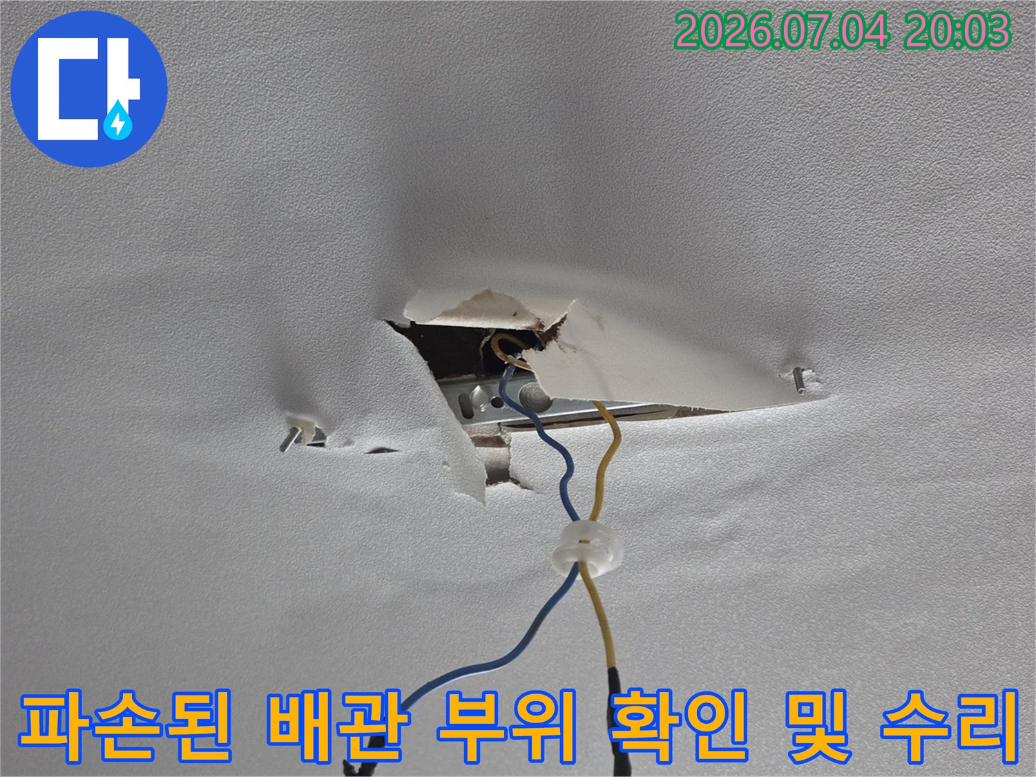 천장 내부에 노출되어 파손된 배관 연결부를 점검하는 장면