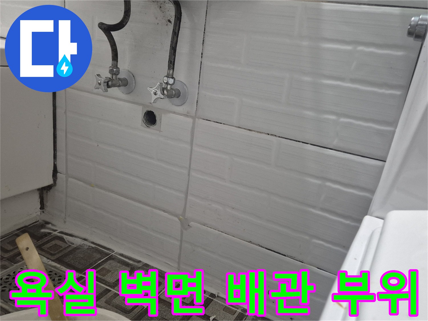 화장실 벽면에 설치된 수도꼭지와 배관 연결부 모습입니다.