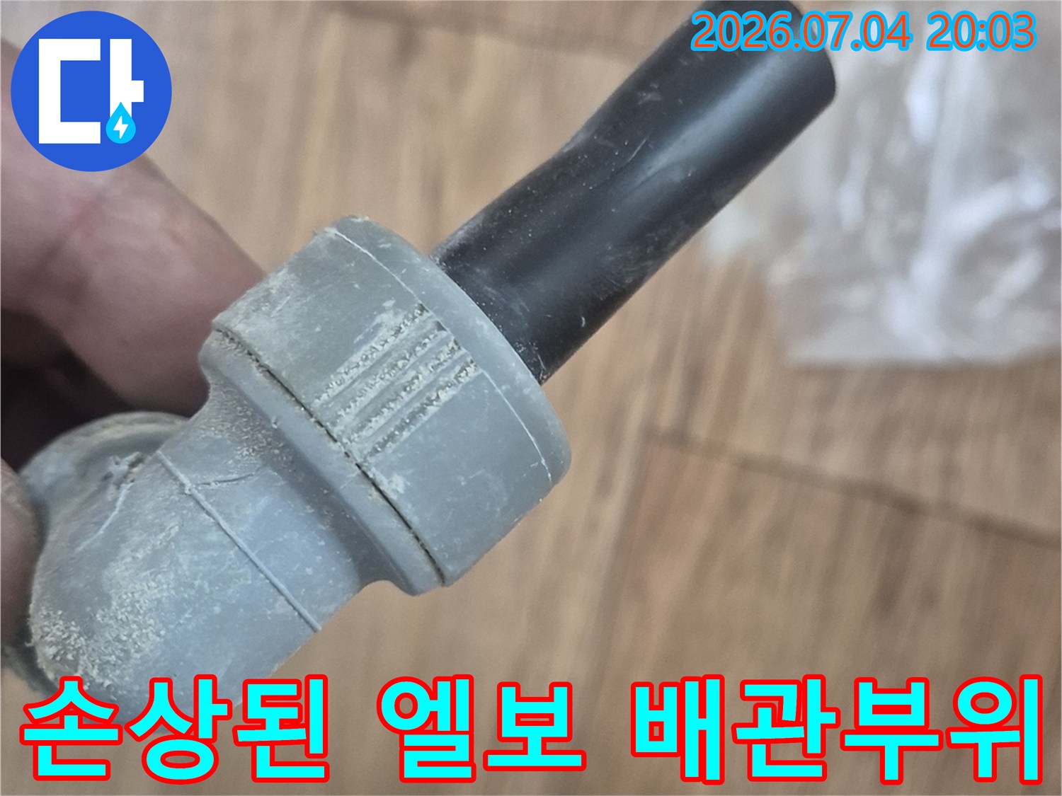 흙과 먼지가 묻은 상태의 노출된 파손 배관 부위