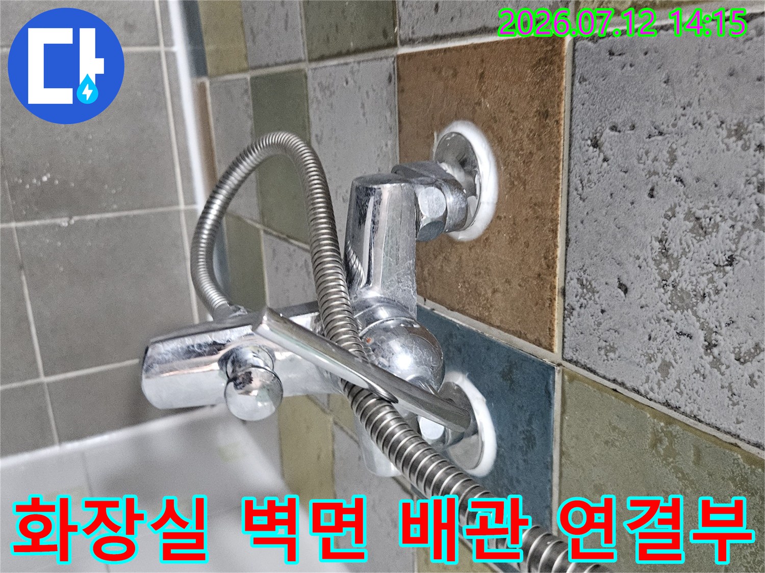벽면에 고정된 세면대 공급 배관과 금속 수전의 모습