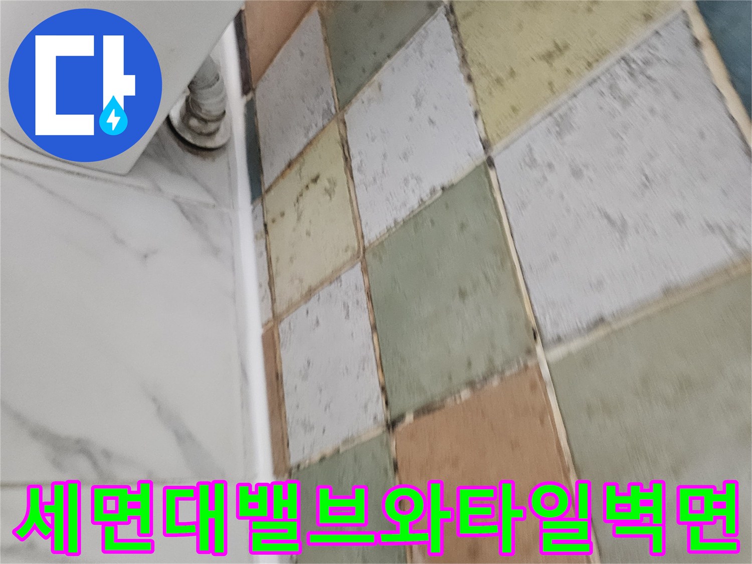 세면대 하단 급수 밸브와 주변 타일의 근접 모습