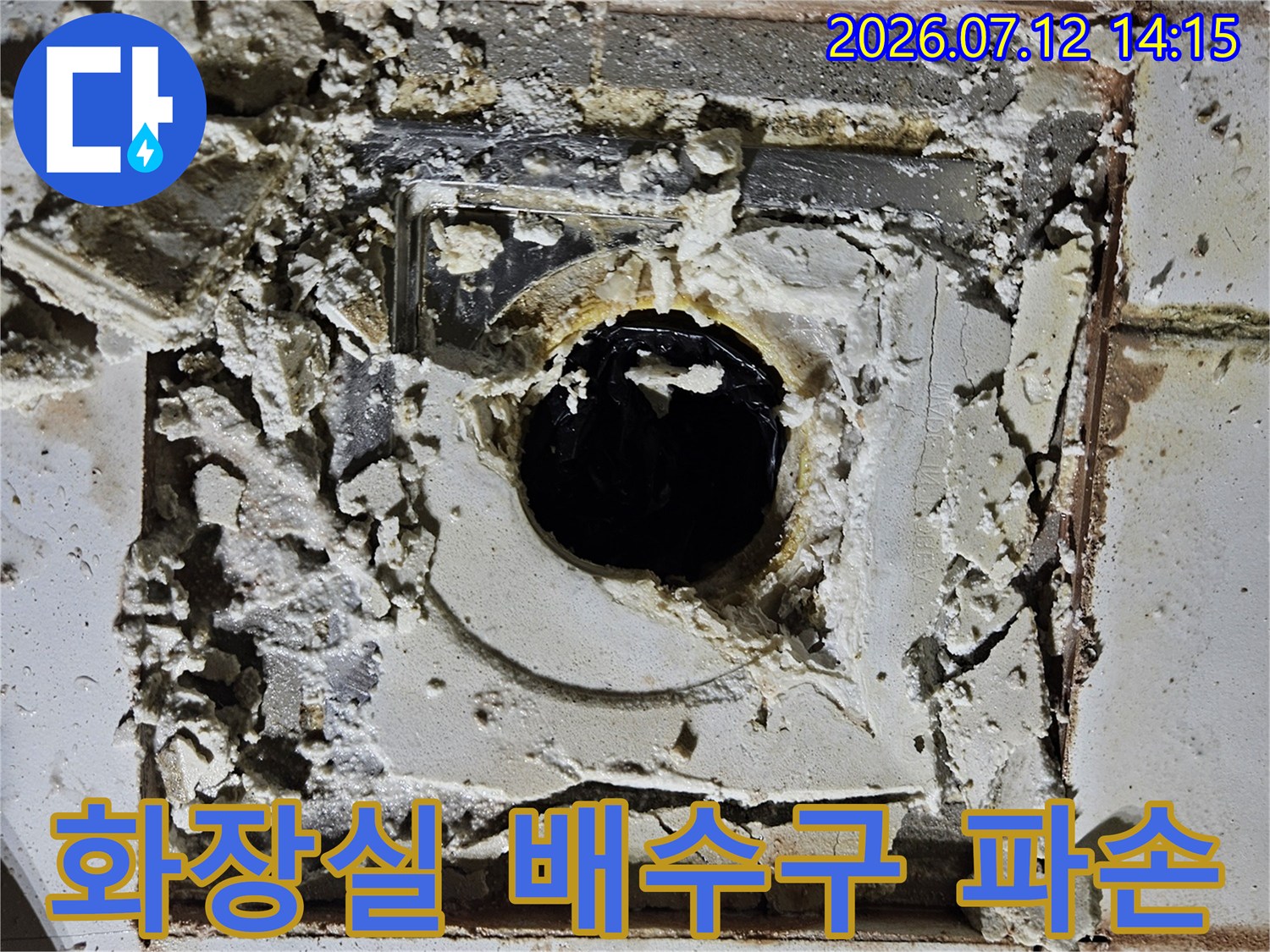 파손된 타일과 노출된 배수구 배관 부위