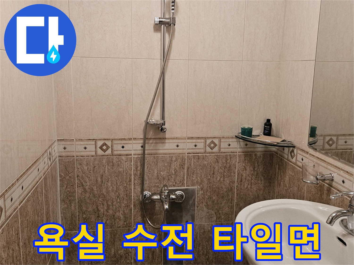 욕실 세면대와 샤워기 수전이 설치된 타일 벽면 사진