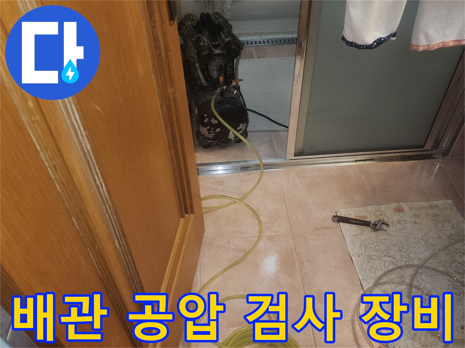 욕실 벽면에서 진행하는-배관 압력 테스트 장비와 호스