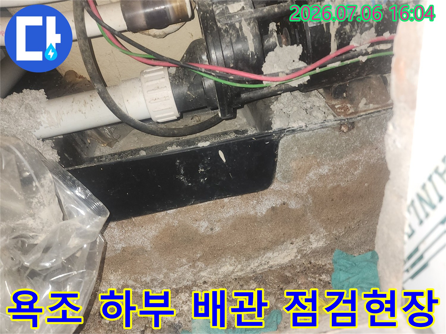 욕조 아래 공간에서 노출된 수도용 배관과 주변 마감재의 상태를 확인하는 모습