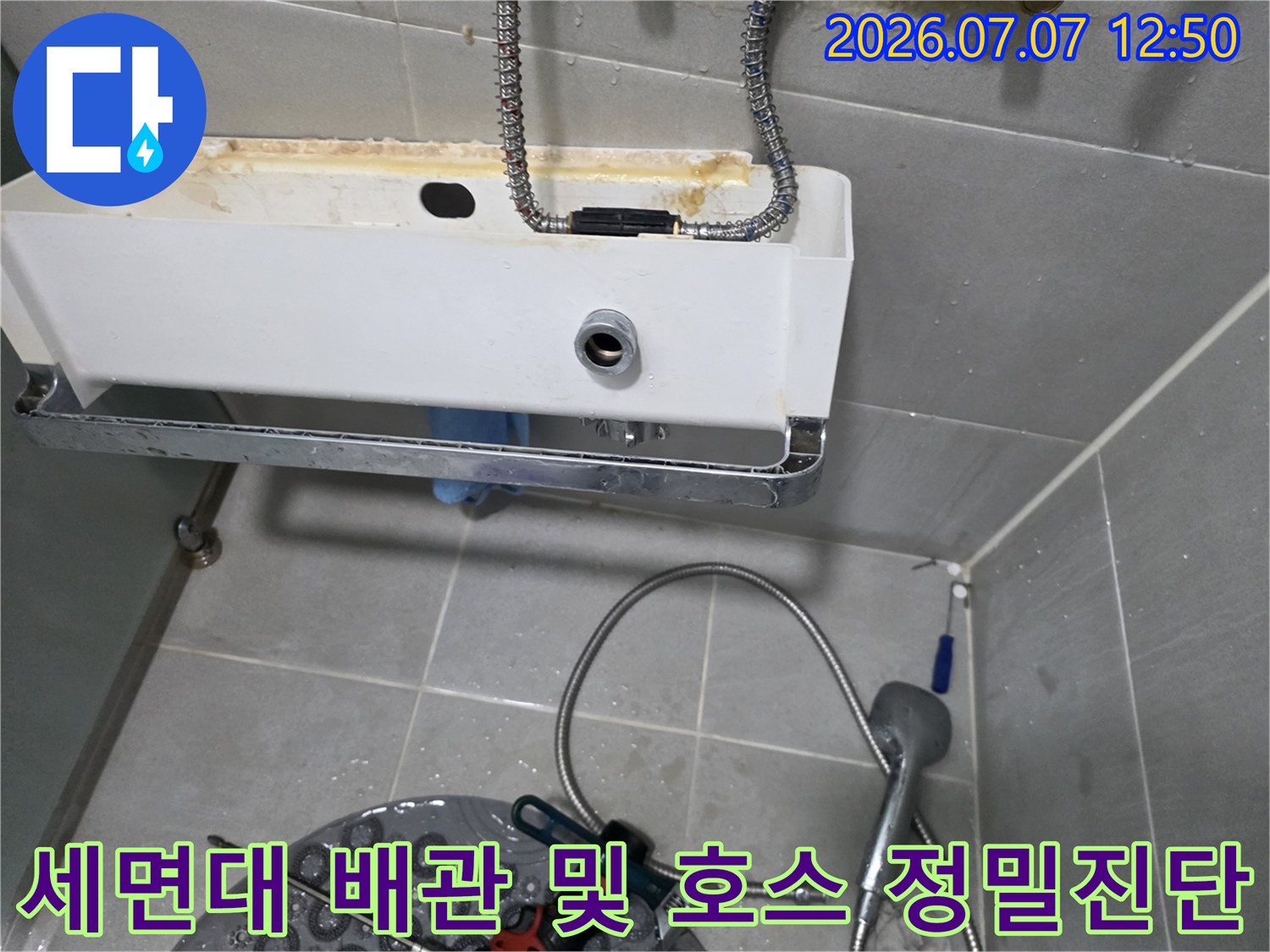 세면대 밑 공간의 노출된 수도용 고압호스와 연결 파이프를 점검하는 사진