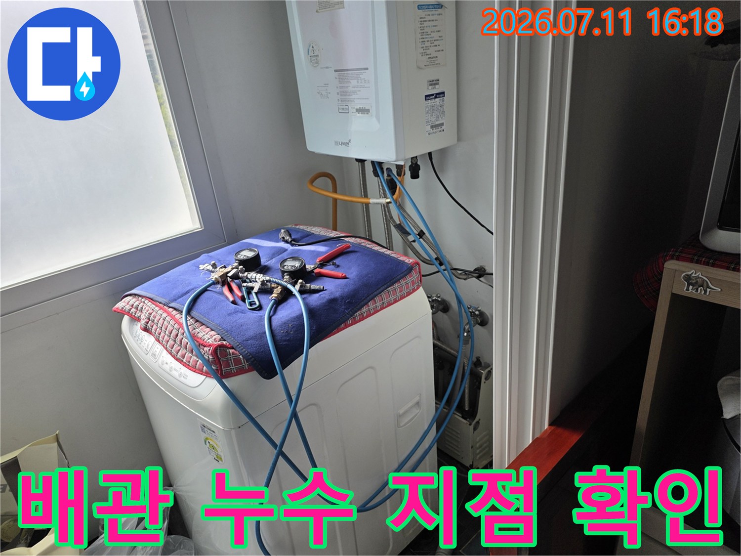 수리용 매트 위에서 세탁기 수전 연결부를 점검하는 모습