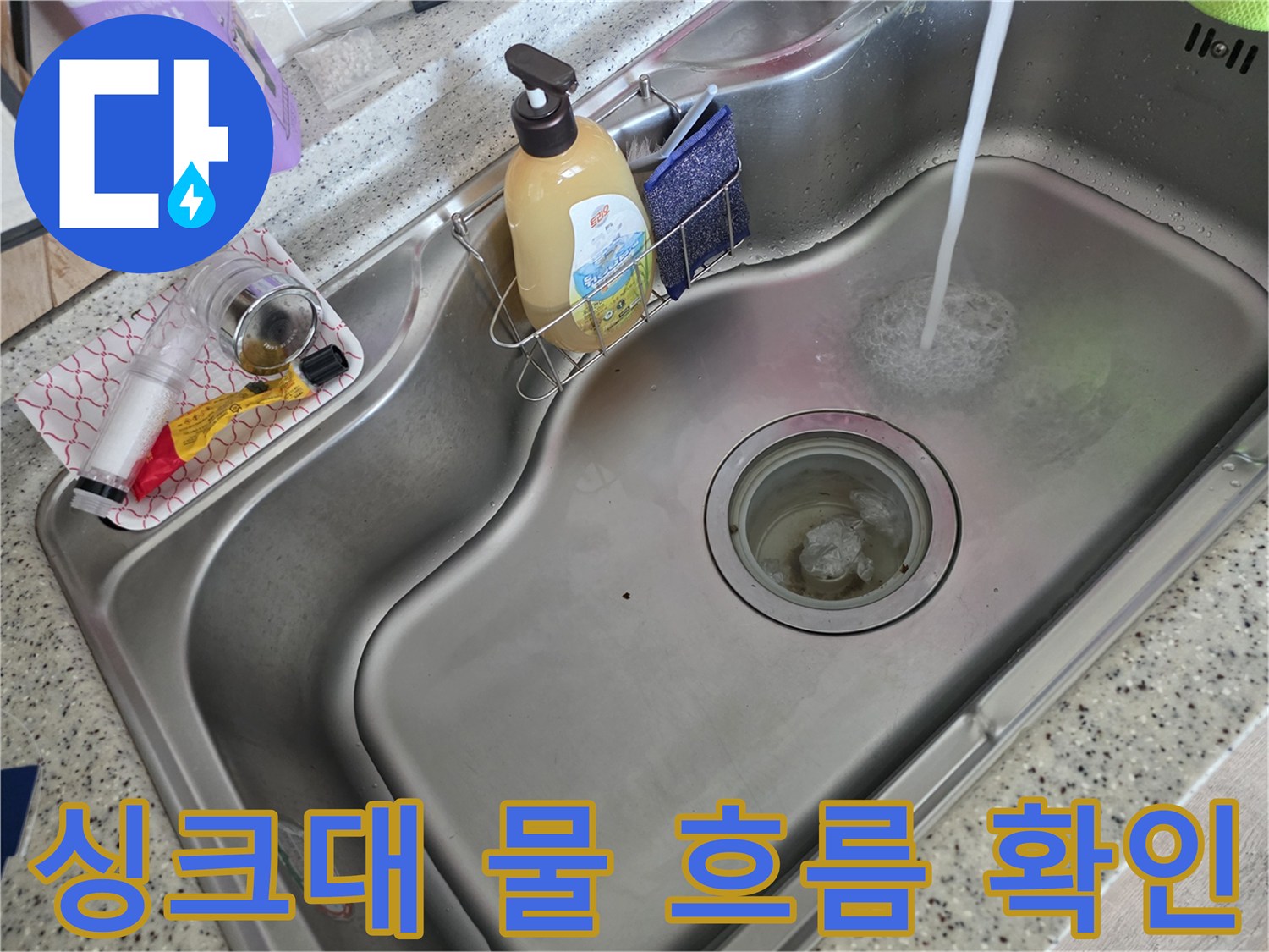스테인리스 싱크대에 물을 내려 배수 상태를 점కి하는 모습