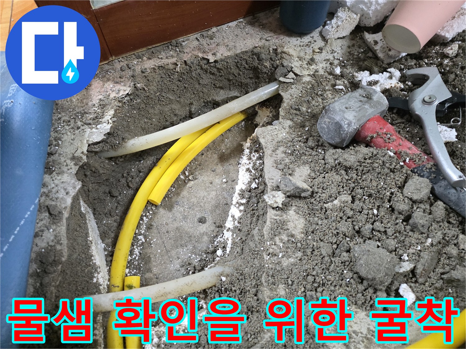 누수 지점을 찾아내기 위해 바닥을 파낸 뒤 드러난 노란색 배관과 공구