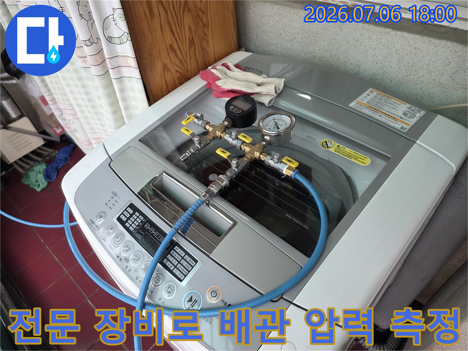 누수 탐지를 위해 세탁기 위 배관에 연결된 가스 및 공압 검사 장비