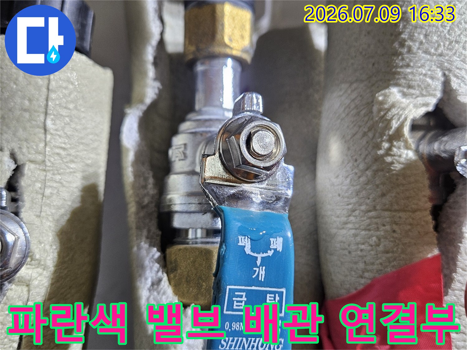노출된 파란색 밸브와 금속 재질의 배관이 연결된 지점 점검