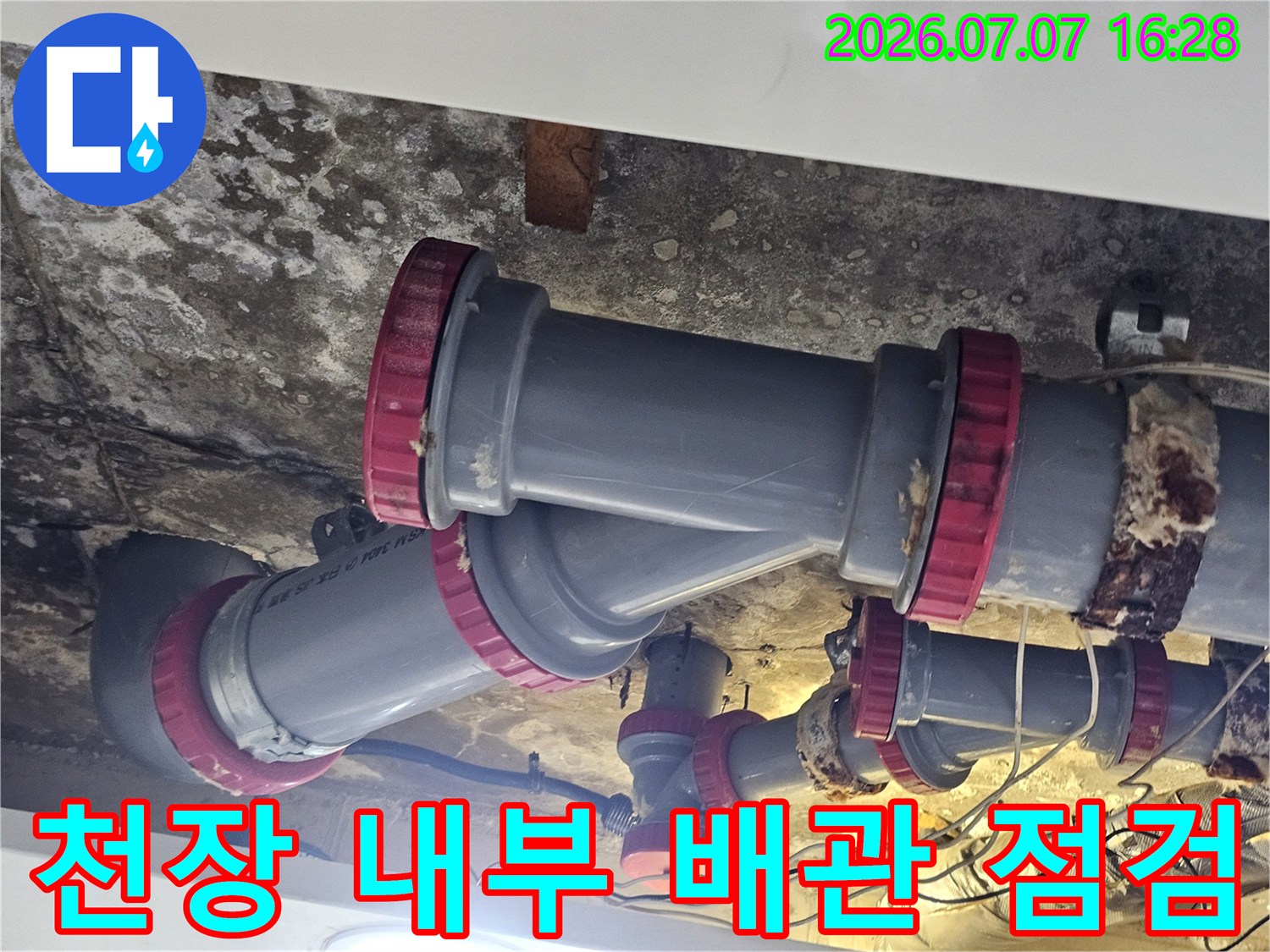 회색 배수 파이프와 붉은색 연결 부품을 통해 누수 지점을 추적하는 현장 사진