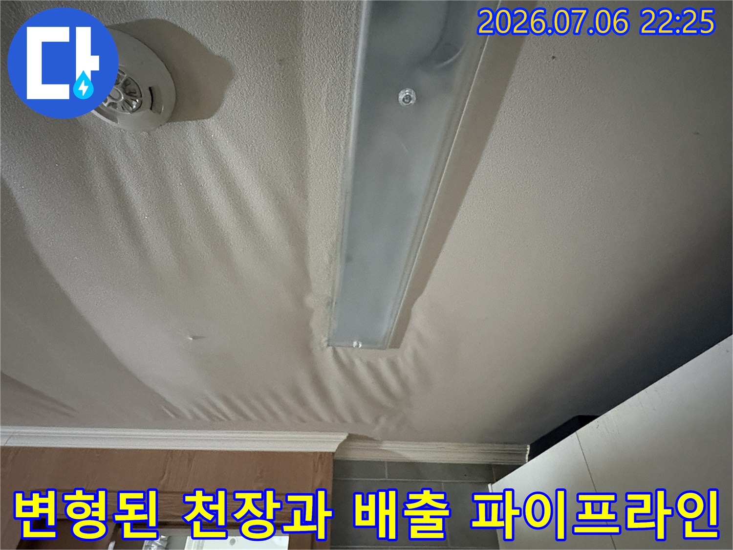 상부 배수관 주변의 습기로 인해 굴곡진 부분의 벽지가 변형된 모습
