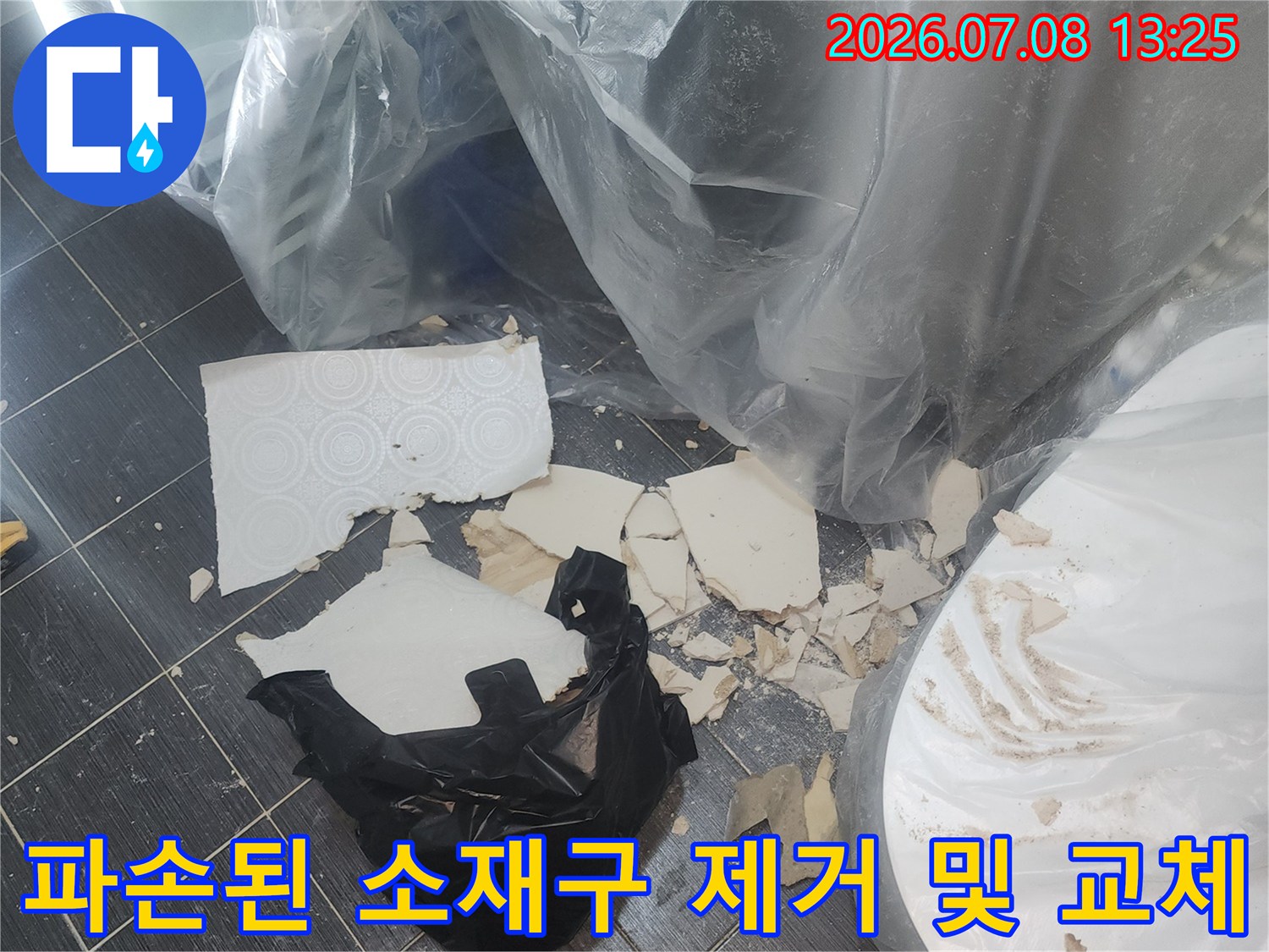 깨진 배관 연결부 파편과 새 부속으로 이어지는 수선 작업
