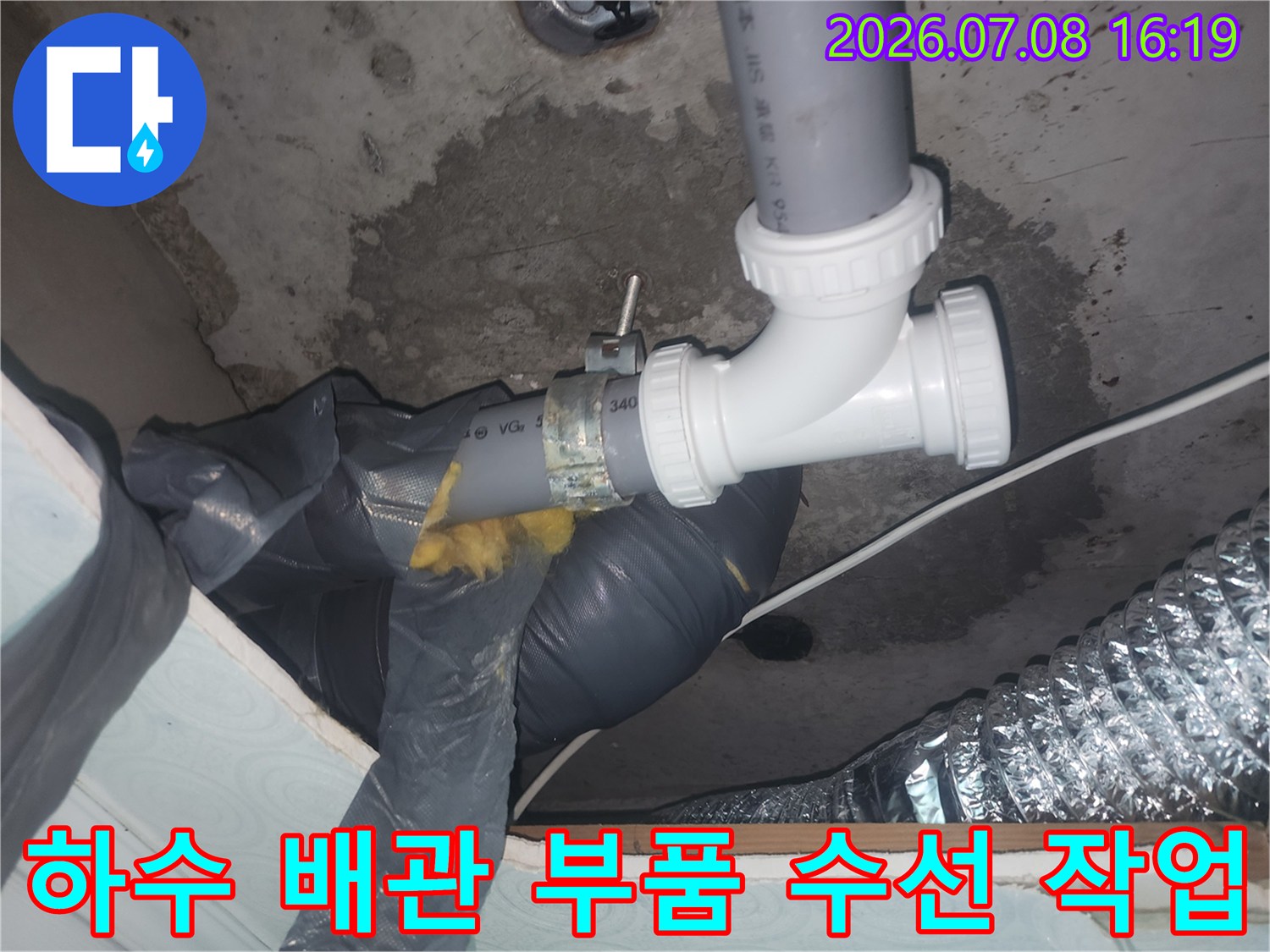 화장실 천장 하수 배관 연결부의 노후 및 파손된 소형 부속을 새것으로 교체하는 모습
