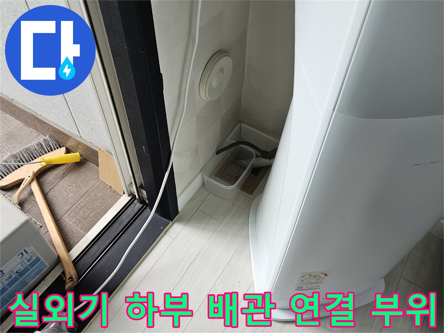 에어컨 실외기 밑바닥 타일과 흰색 배관의 접합 부분