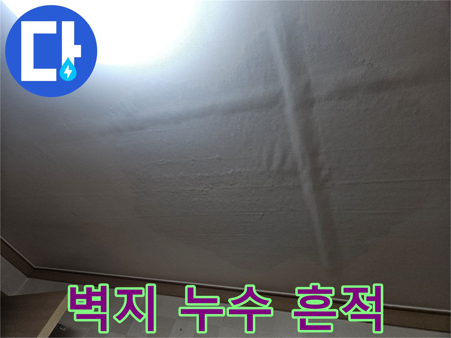 천장 벽지를 따라 넓게 퍼진 젖은 자국과 변색된 부위