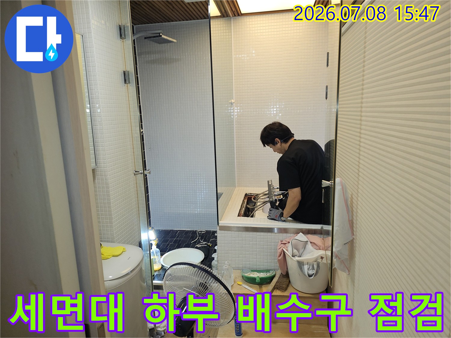 전문가가 세면대 아래쪽 배수 트랩과 연결 부위를 꼼꼼하게 살피는 현장 사진