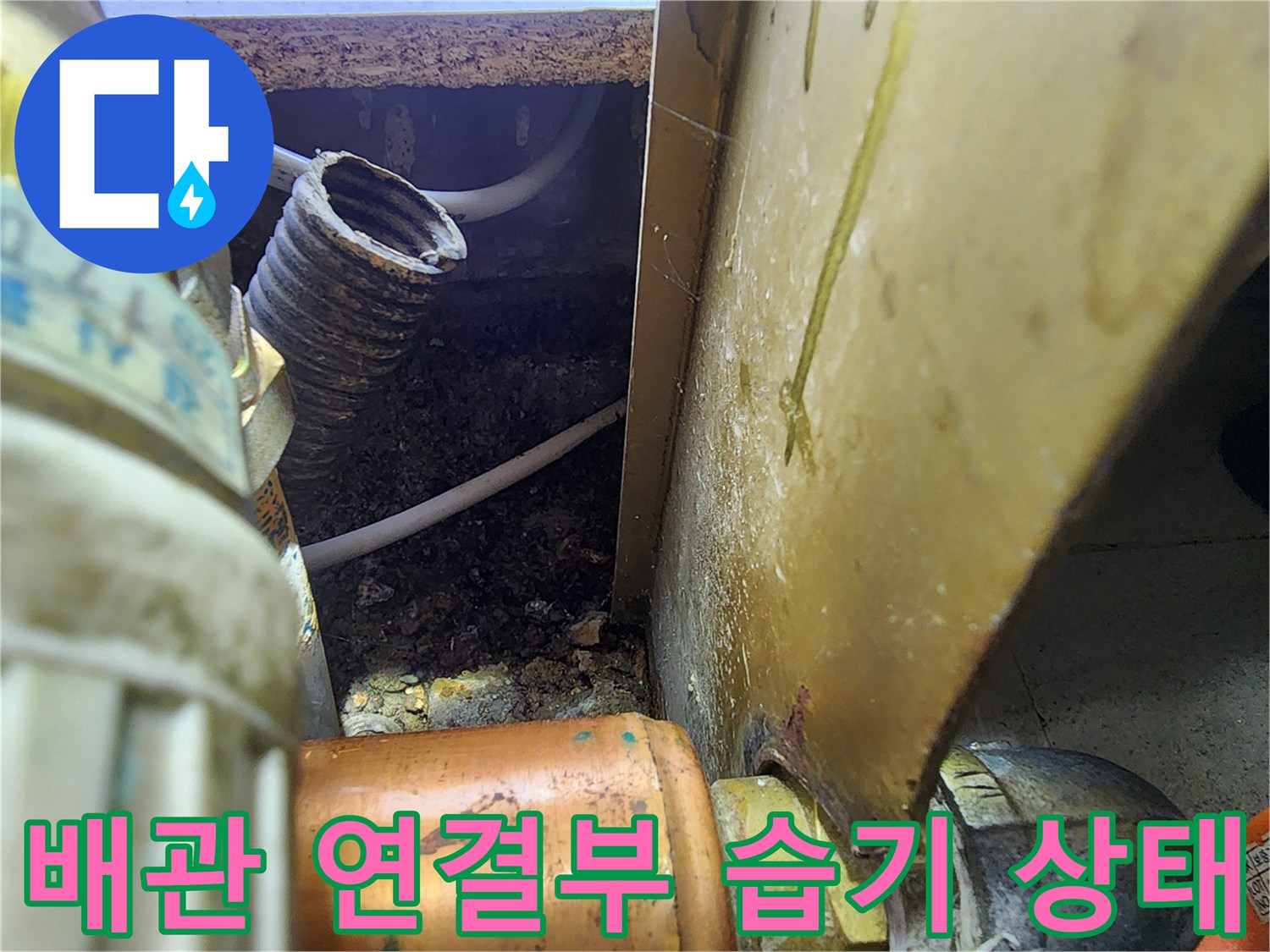 주방 배관-연결 부위의 젖은 흔적과 주변 오염물질을 촬영한 사진입니다.
