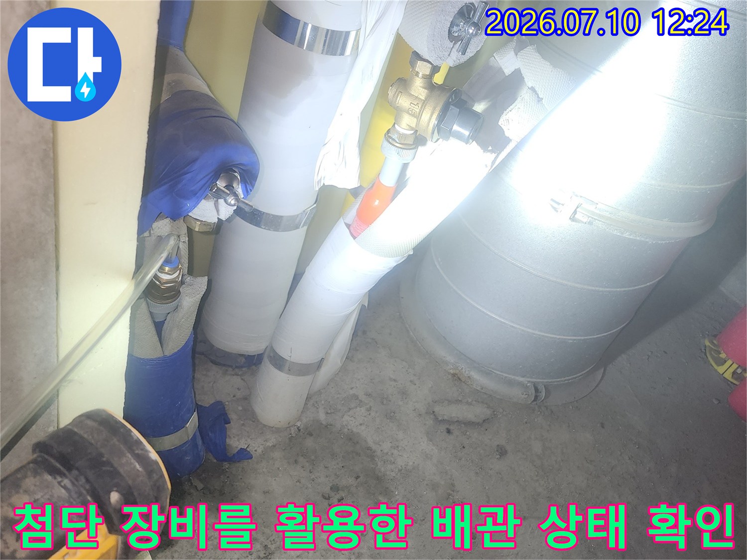 배관 누수 여부를 판단하기 위해 내시경과 압력 게이지를 연결하여 점검하는 모습