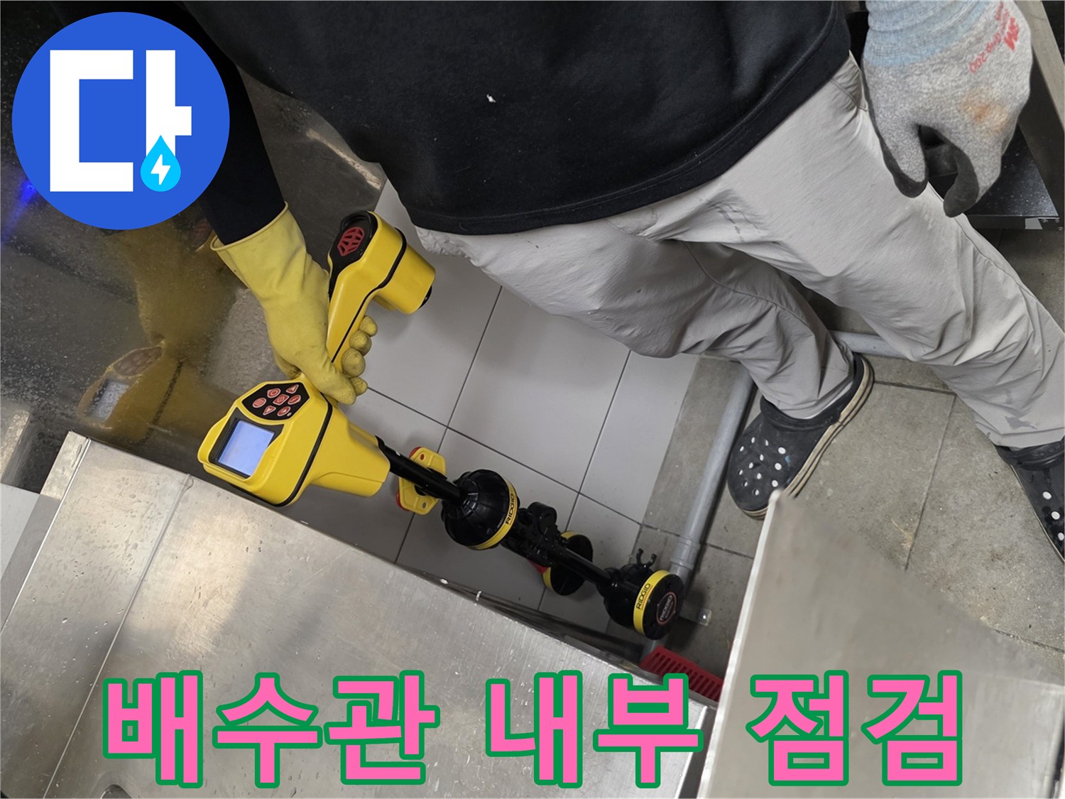 노란색 내시경 탐지기를 활용하여 배관 속 막힘 구간을 추적하는 장면