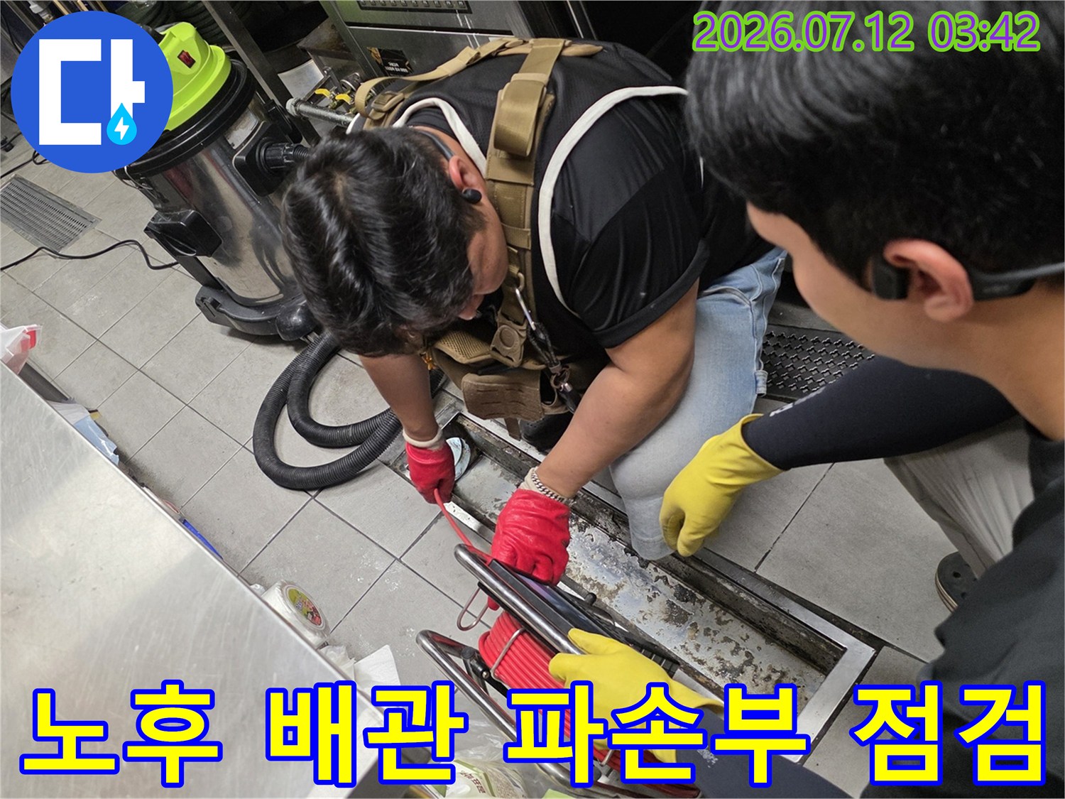 장갑을 끼고 트렌치 내부에 노출된 배수관을 손으로 확인하는 작업 모습