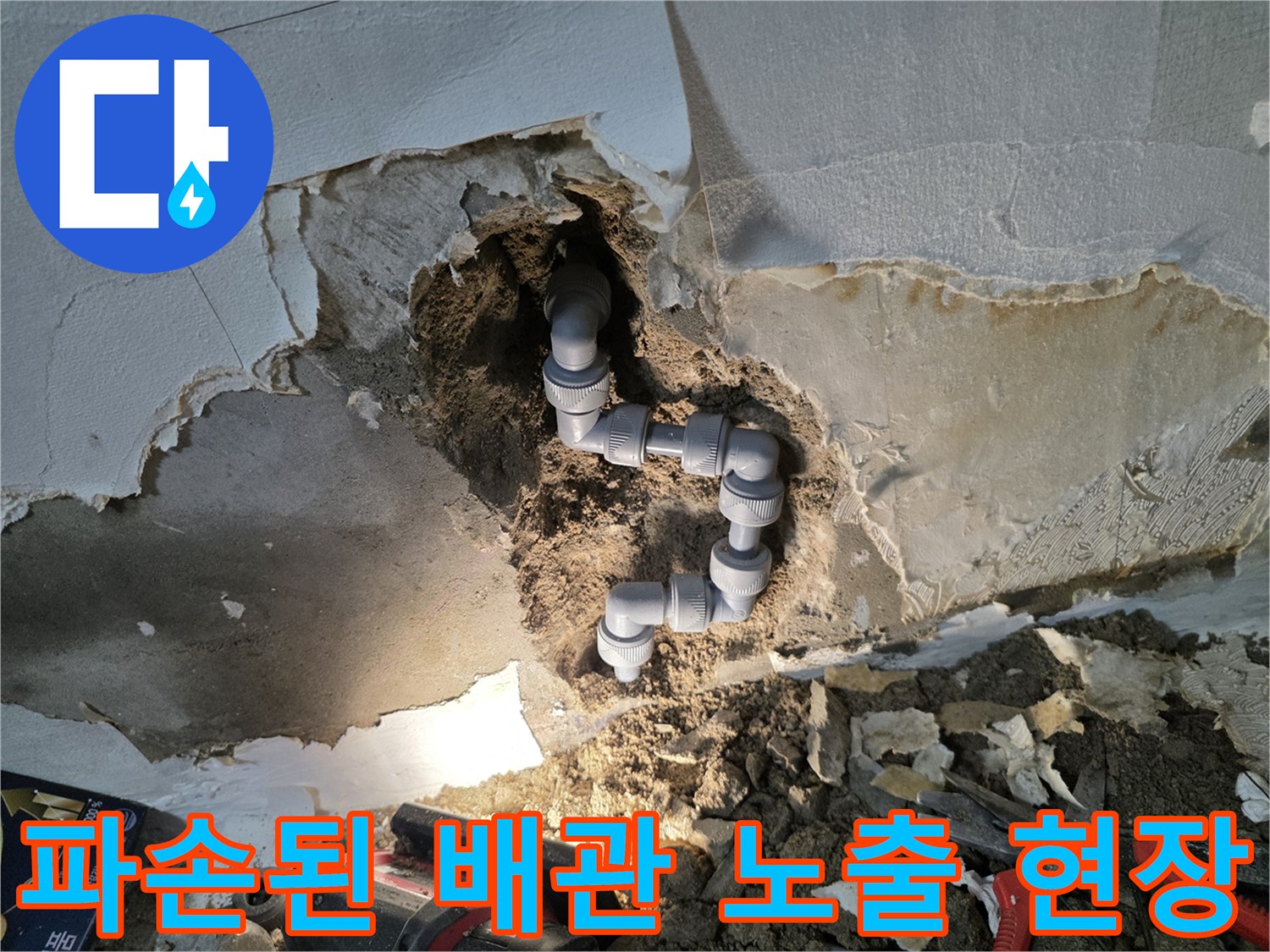 물에 젖은 벽 내부의 회색 배관과 파헤쳐진 시멘트층