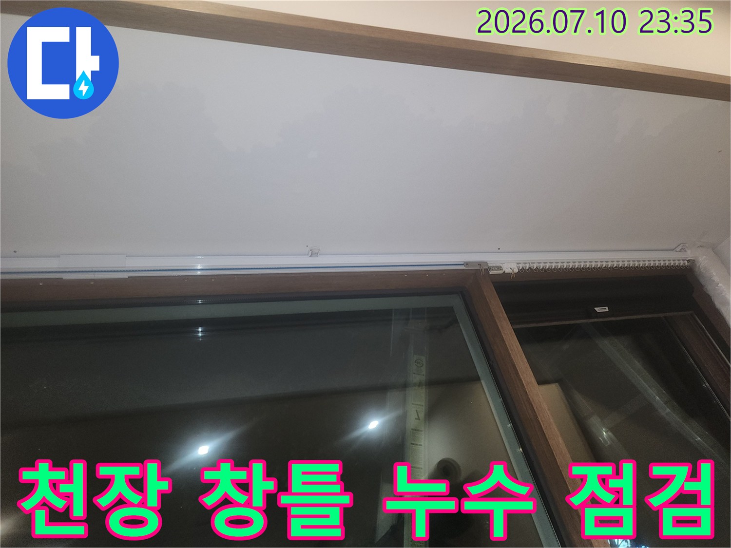 창문 위쪽 천장 경계면의 습기 및 오염 상태를 점검하는 모습