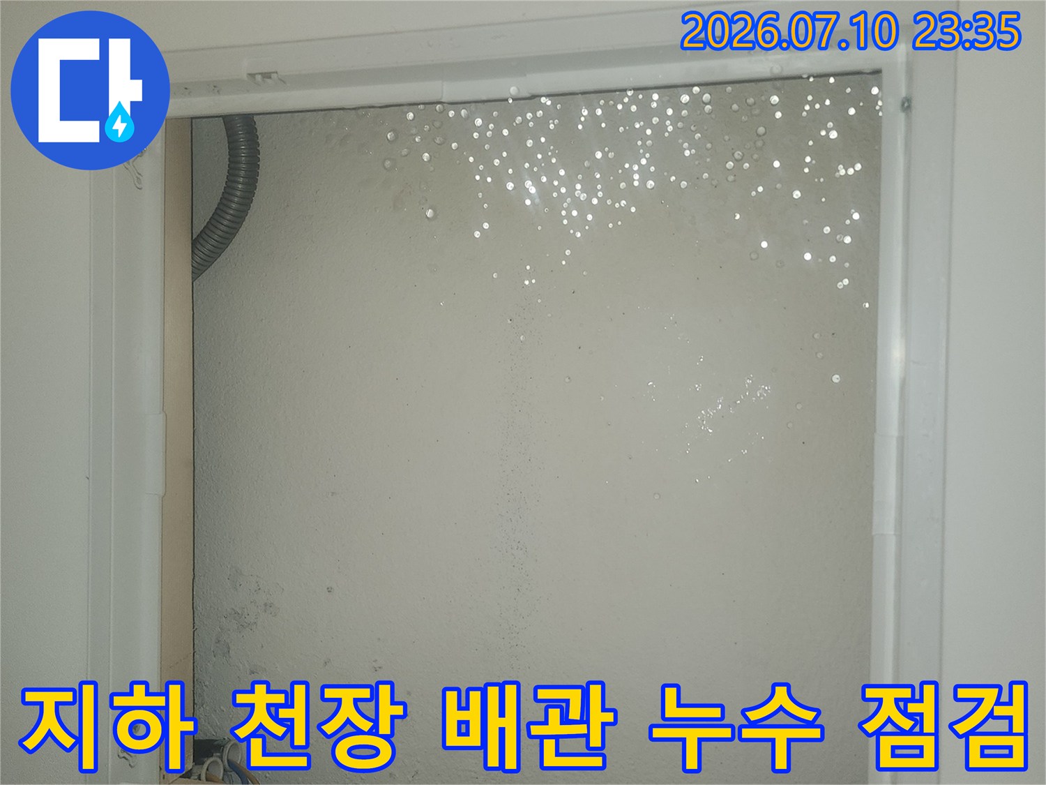 창틀 주변의 습기로 인한 오염이 발생한 지하 천장 및 노출된 배관 모습