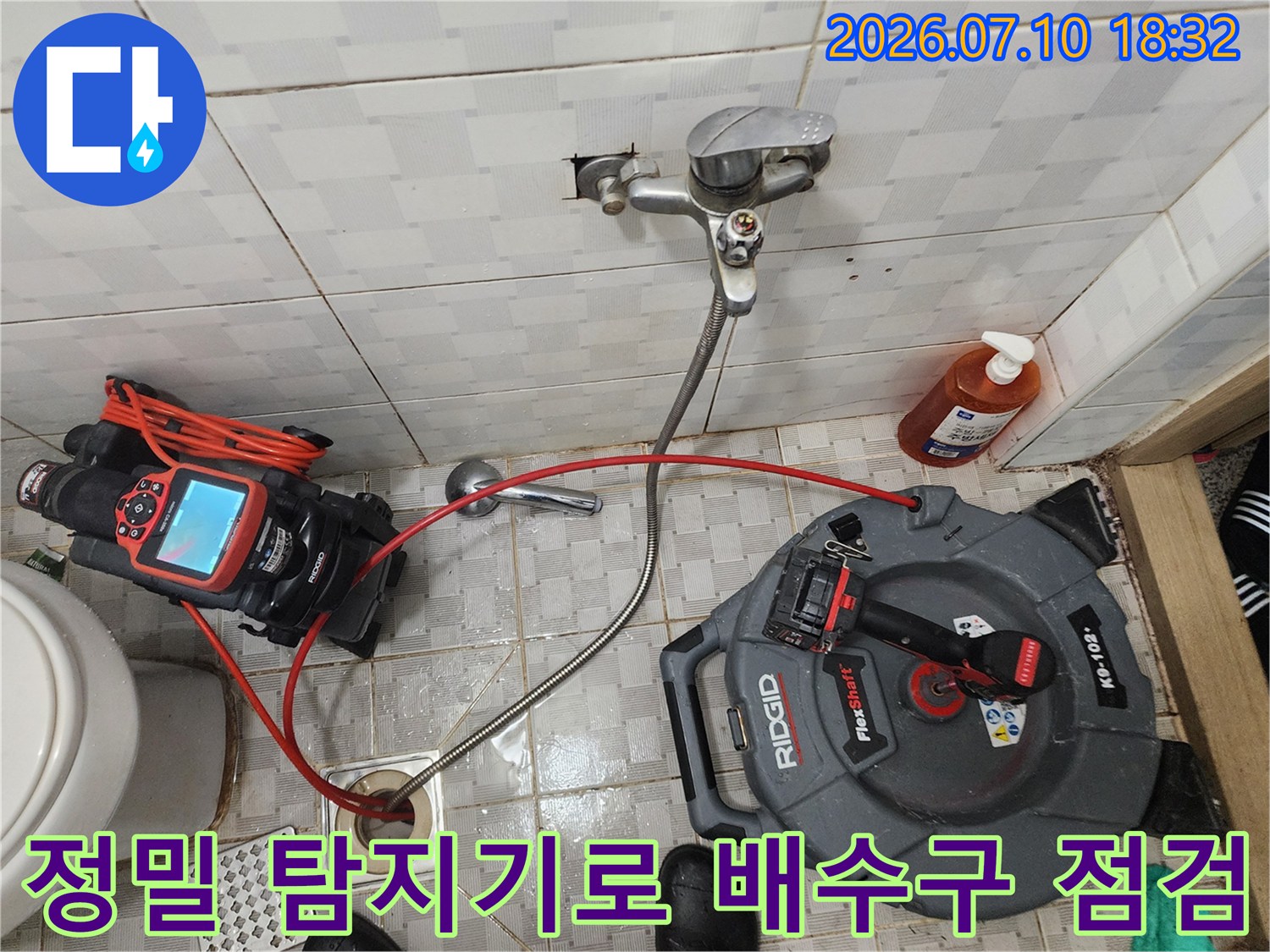 화장실 바닥에 설치된 배수구 주변을 전문적인 누수 탐지 장비로 꼼꼼하게 점검하는 모습