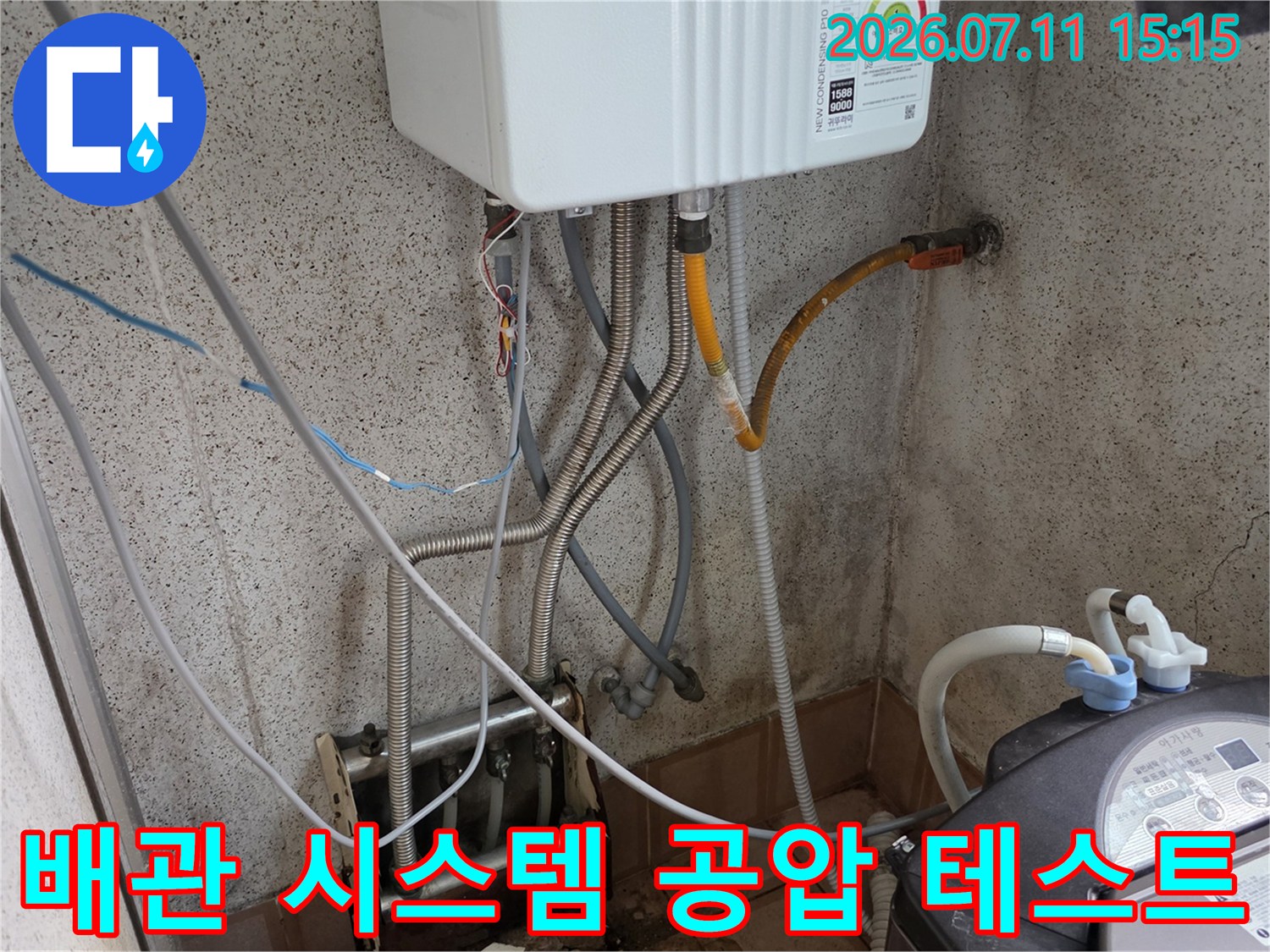 보일러실 배관에 연결된 호스와 압력계로 누수 여부를 정밀 검사하는 모습