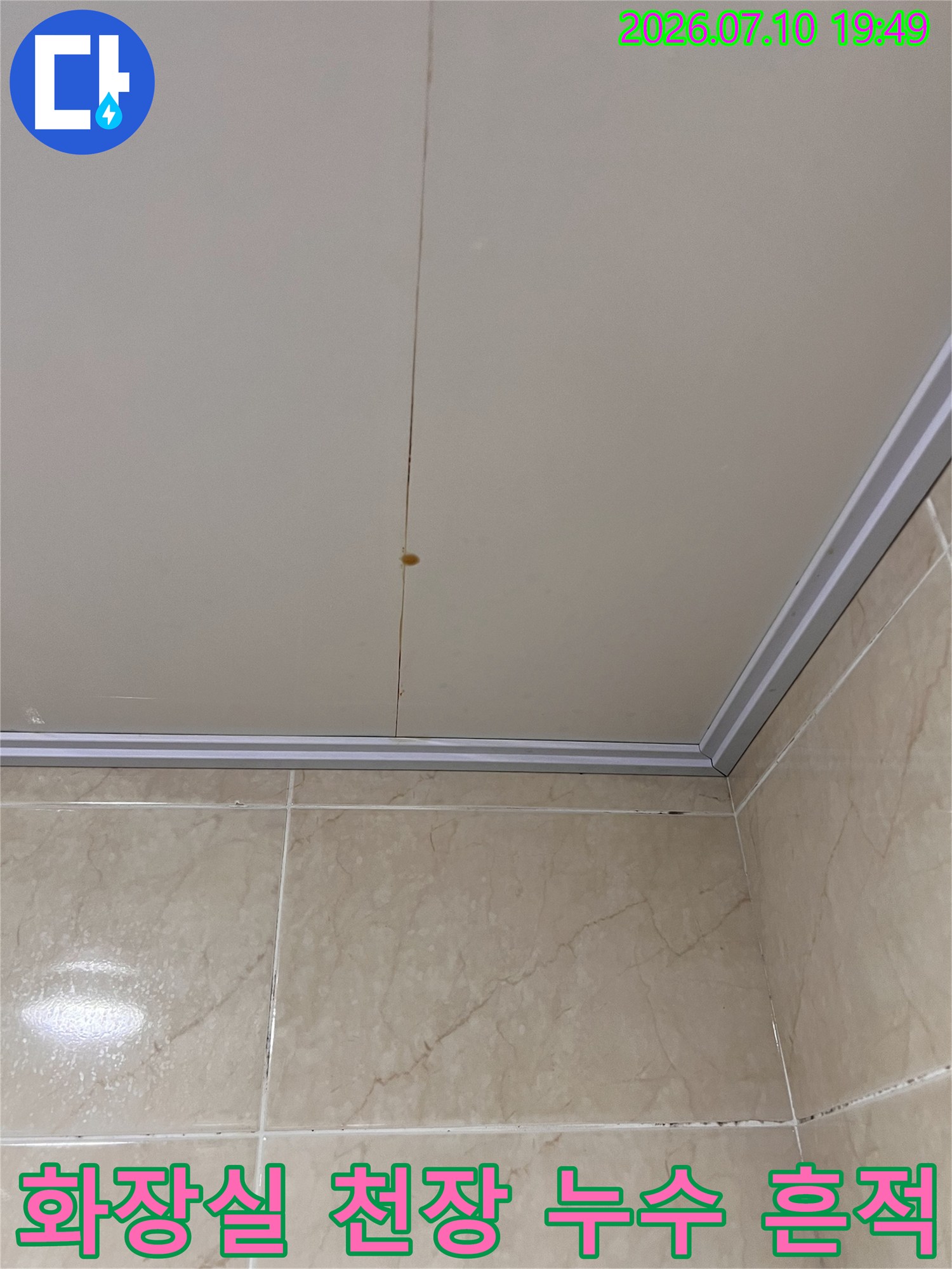 화장실 천장 마감재에 발생한 갈색 누수 얼룩과 물자국