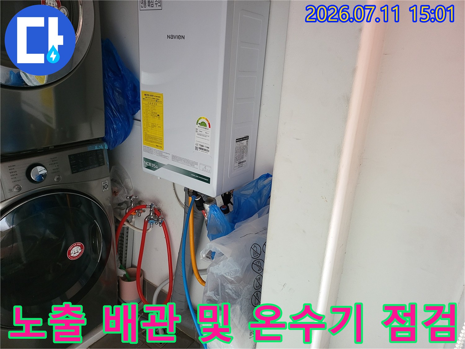 온수기 하단 노출된 수도 배관과 연결 부위를 상세히 점검하는 장면