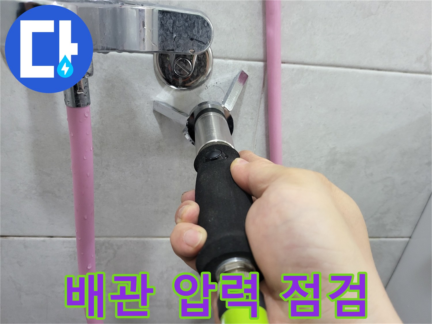 화장실 벽면 수도 배관에 압력계를 연결하여 누수 여부를 확인하는 모습입니다.