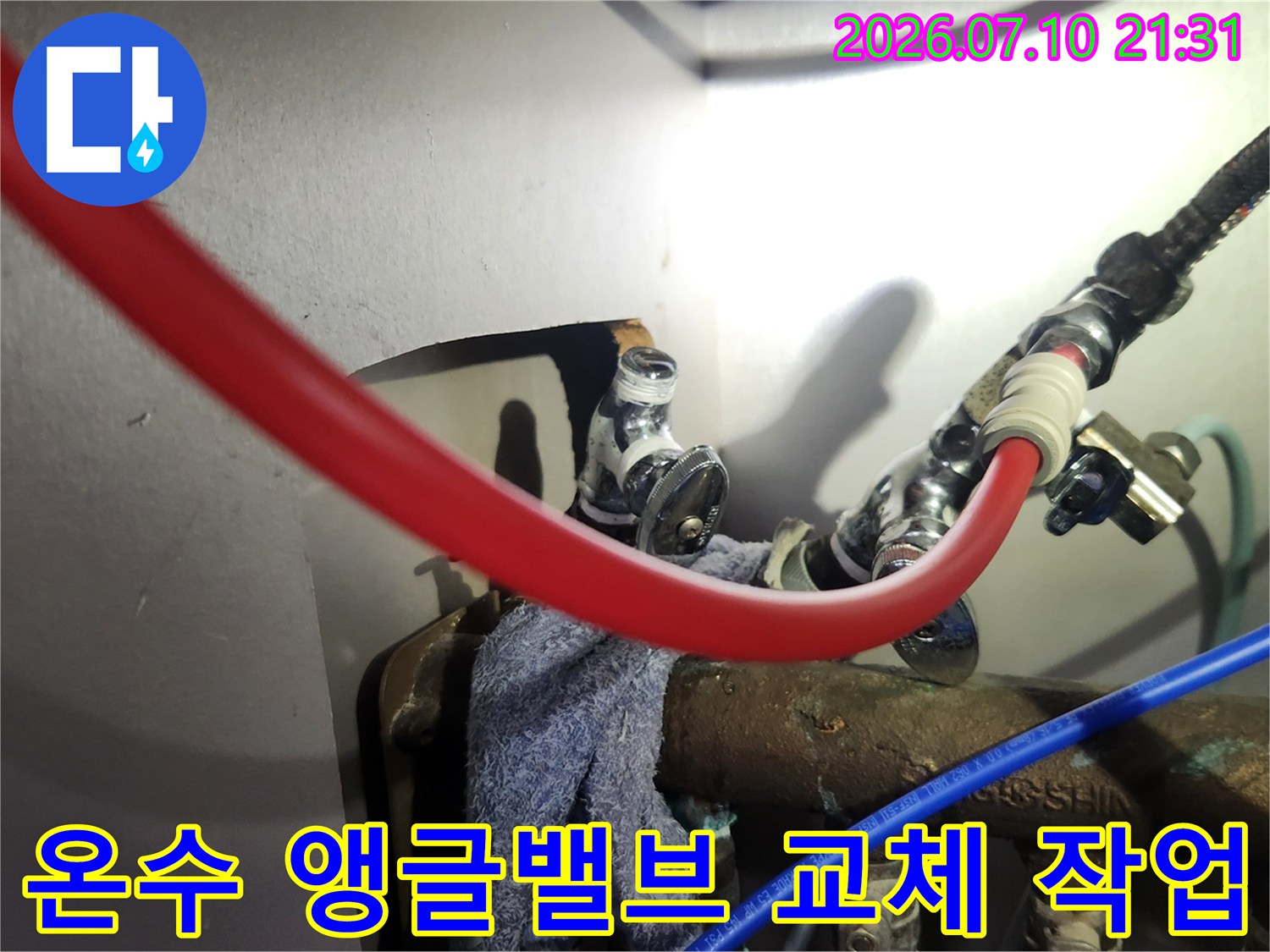 싱크대 하부 온수 배관과 앵글밸브 연결 부위를 수리하는 장면